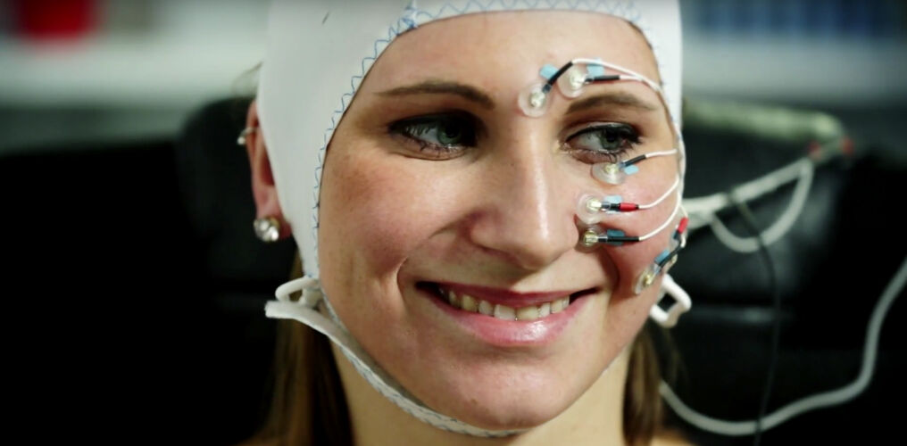 Woman smiles at the sensors on my head and face.