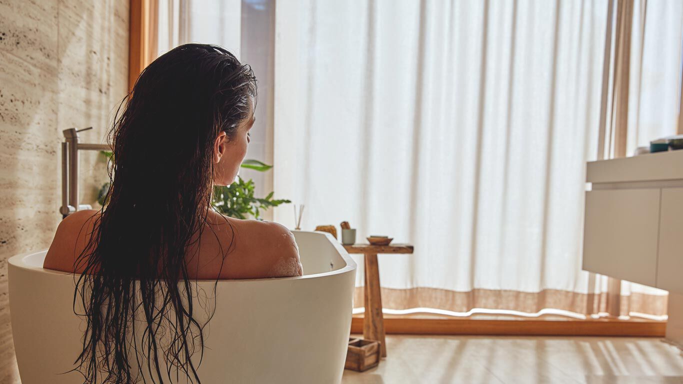 Femme se détendant dans une baignoire.