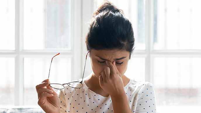 Vrouw wrijft in haar vermoeide ogen.