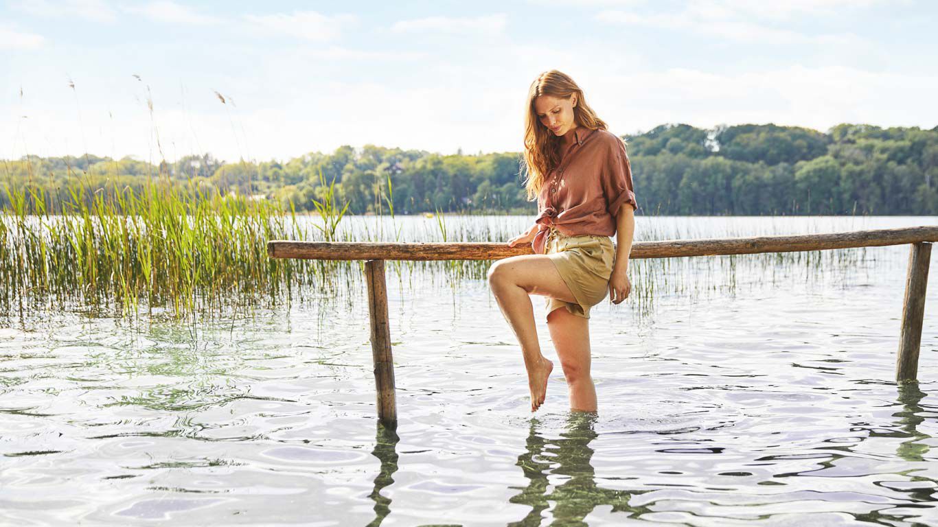 Femme marchant dans l'eau en pleine nature.