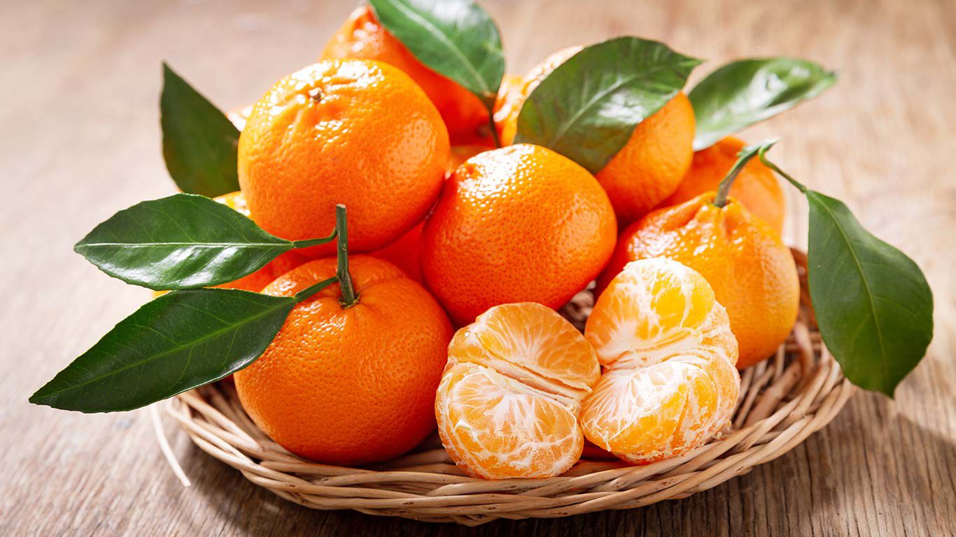 Mandarines dans une coupe tressée sur une table. 
