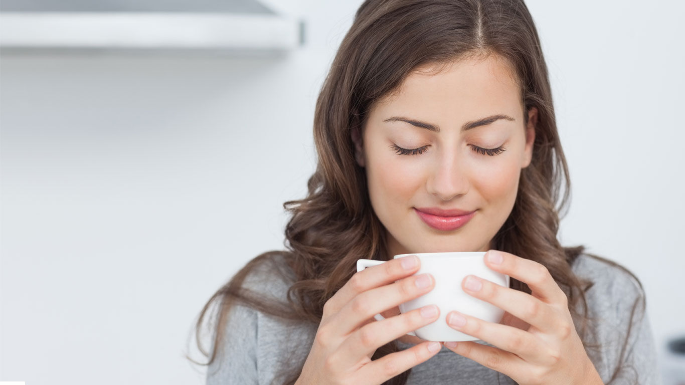 Vrouw ontspant met een kopje thee.