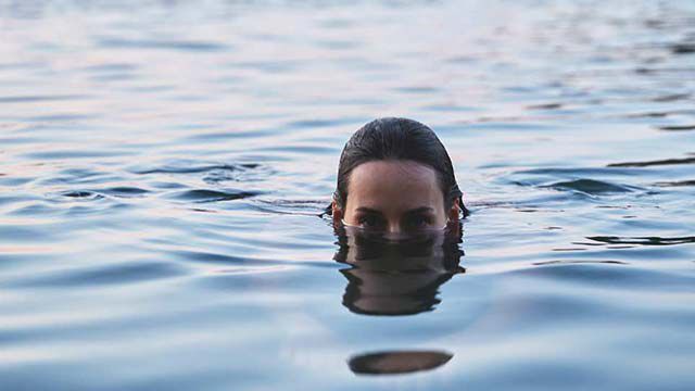 Une femme se baigne dans un lac.
