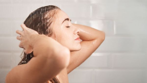 Woman soaping her hair in the shower. 