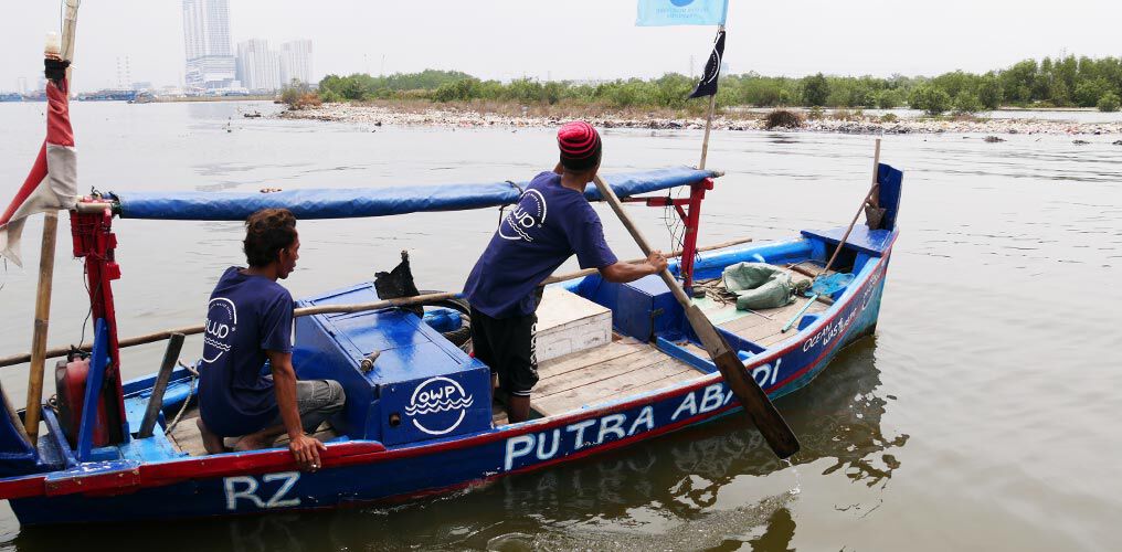 Boot met ReSea-medewerkers op weg om plastic afval te verzamelen.