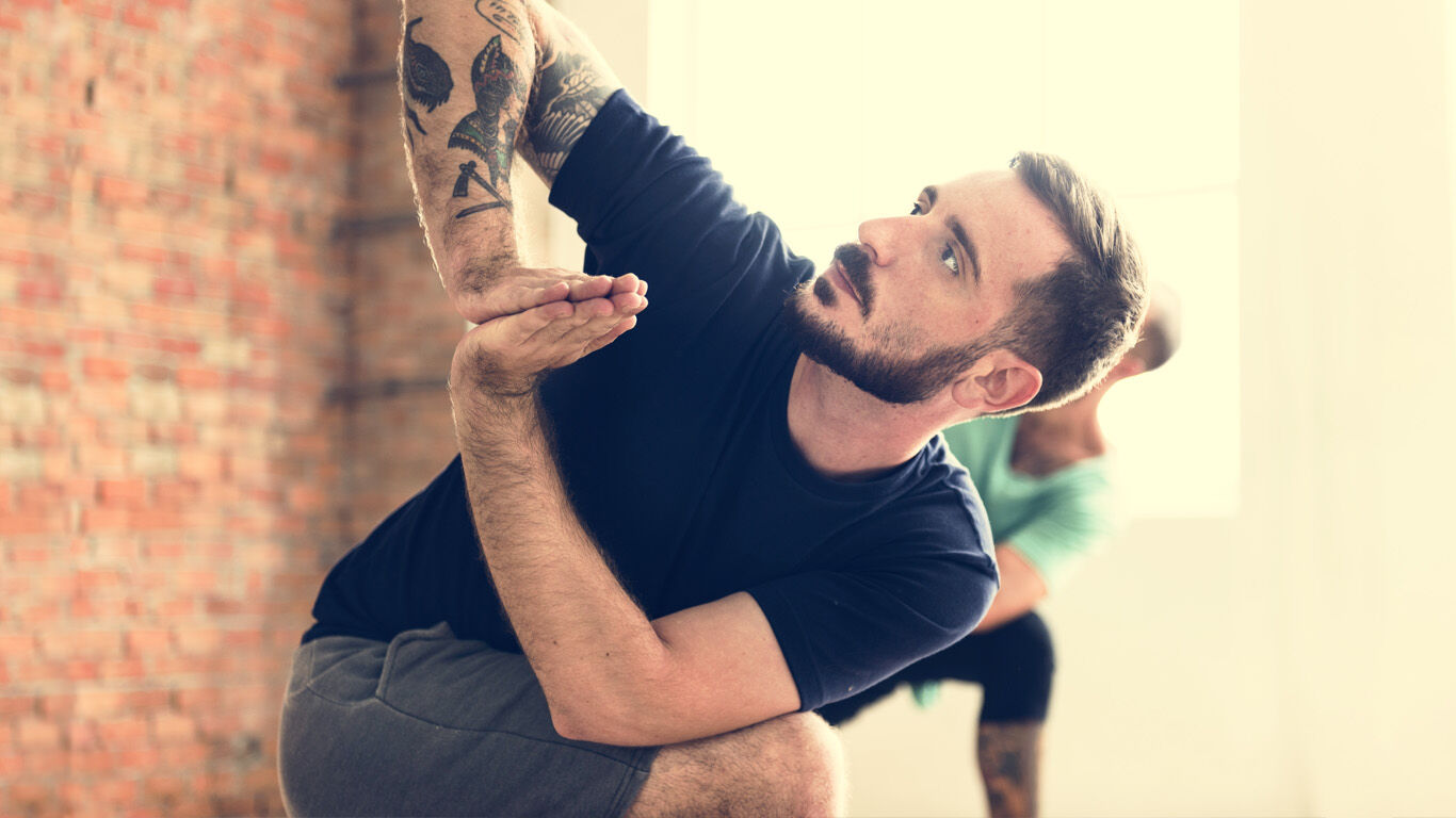 Un homme fait un exercice de yoga.