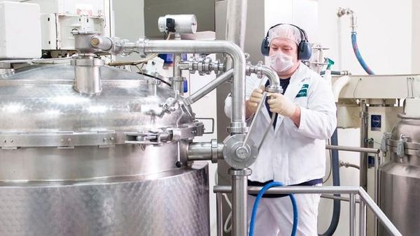 Un homme en tenue de travail et de protection utilise une machine.