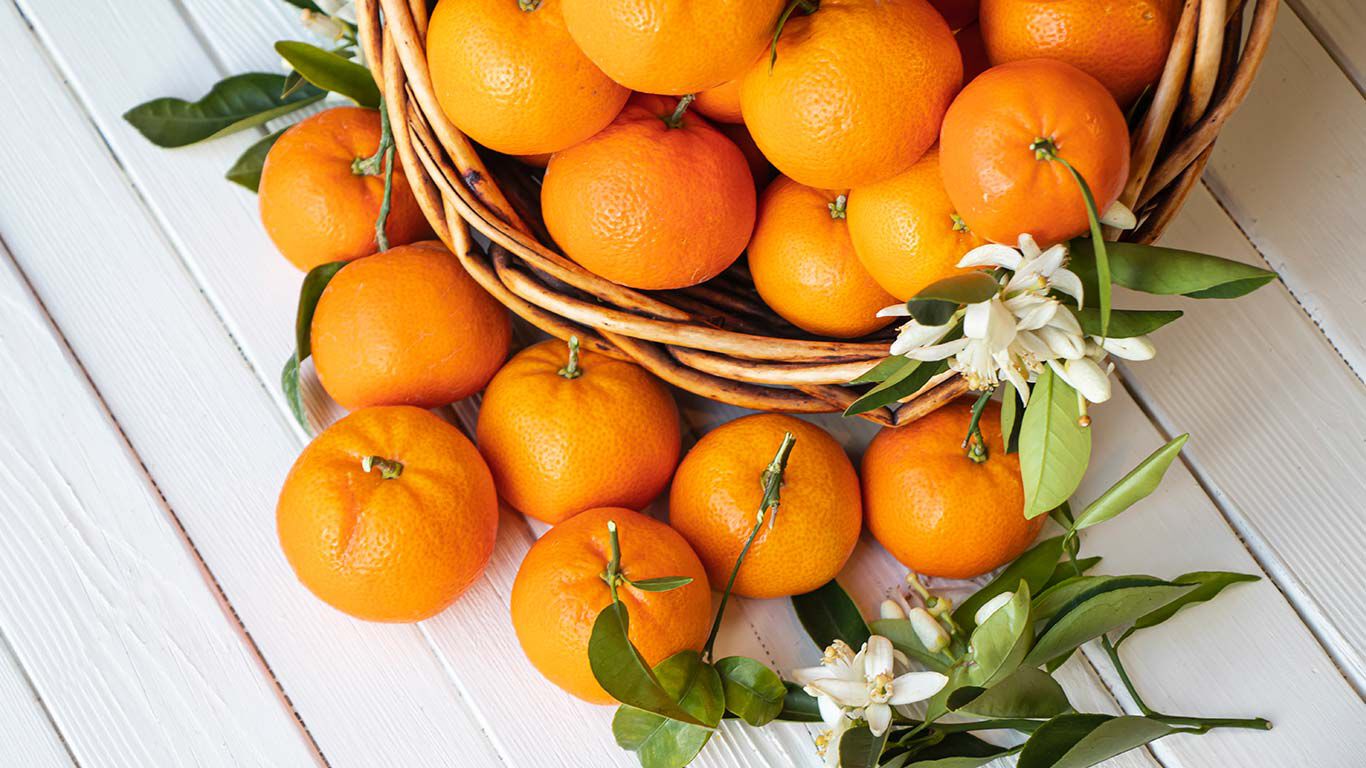 Mandarines dans un panier sur une table en bois blanc