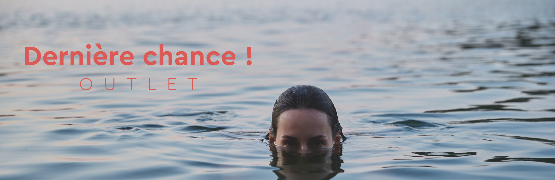 Femme dans l’eau avec les yeux qui dépassent au-dessus de la surface.