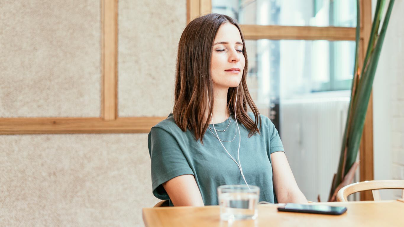 Une femme se d&eacute;tend en &eacute;coutant de la musique.