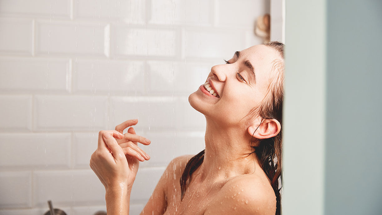 lachende Frau in der Dusche 