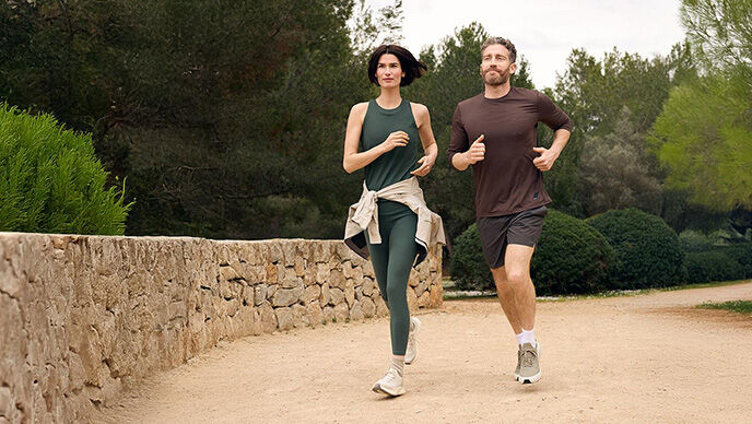 Pärchen in Sportklamotten joggt nebeneinander.