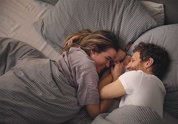 Mann und Frau kuscheln im Bett