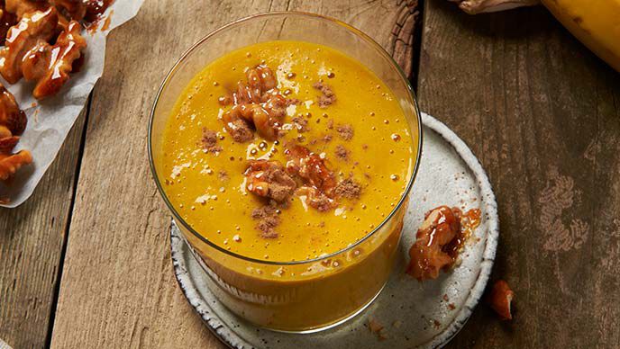 Gelber Schlaf-gut Smoothie von Susanna Bingemer auf einem Holztisch.