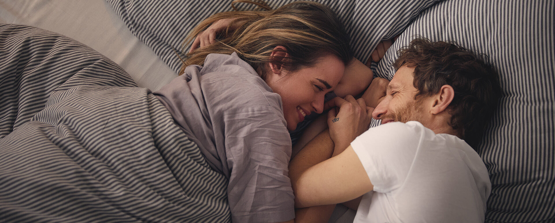 P&auml;rchen kuschelt im Bett.