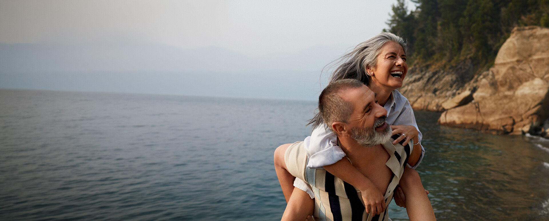 Mann tr&auml;gt Frau Huckepack.