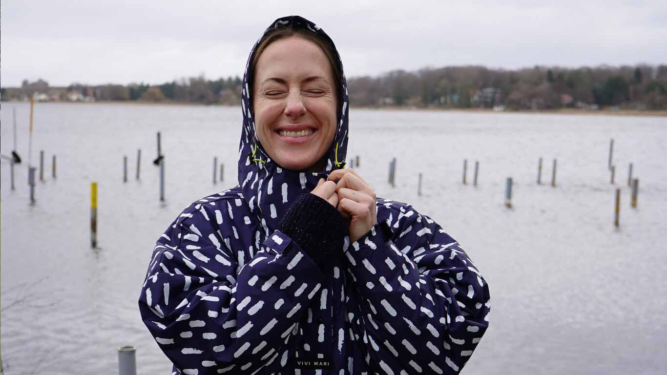 Alexa von Heyden grinsend in ihrem Regenponcho.