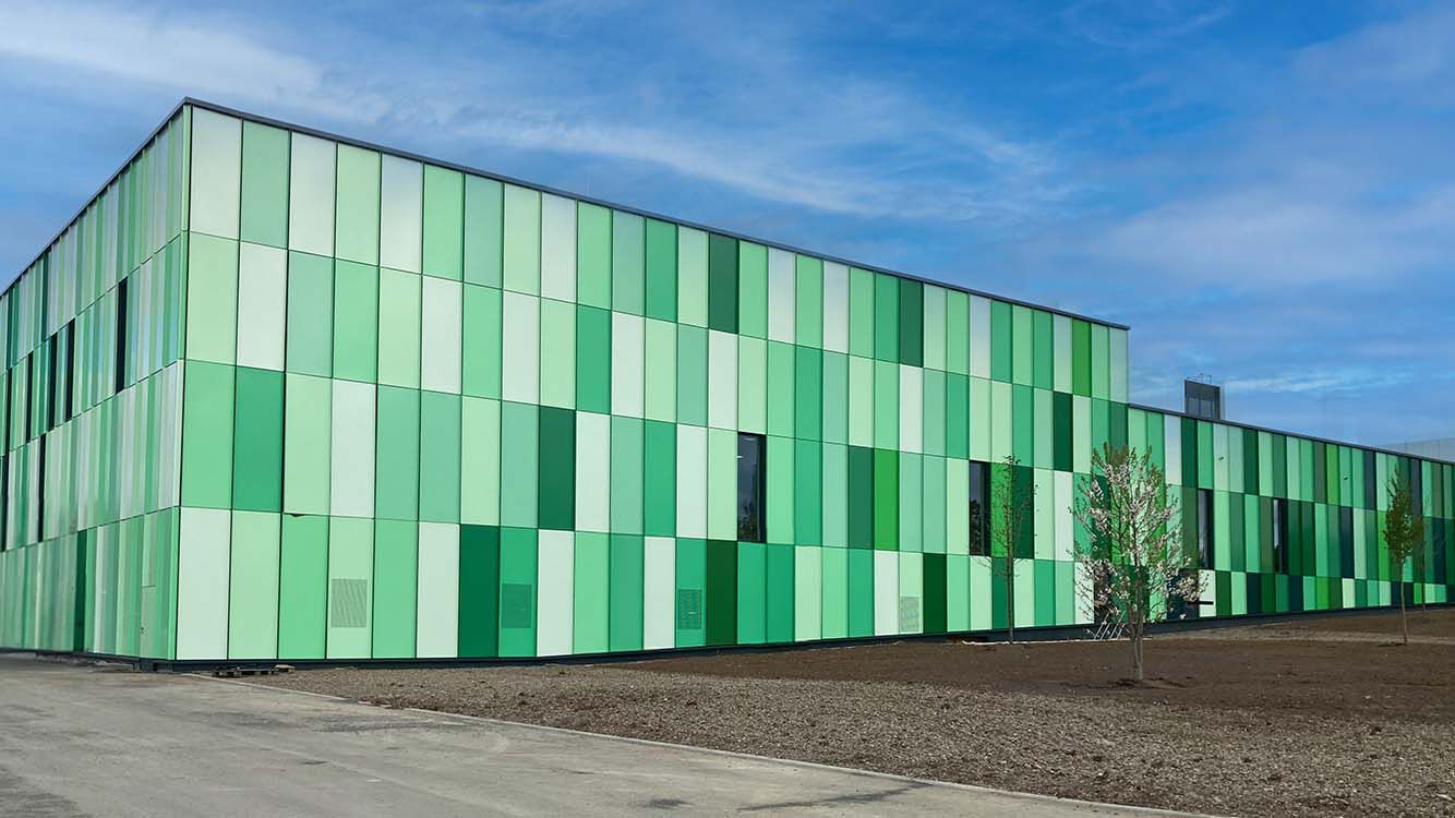 Au&szlig;enansicht der neuen Kneipp Produktionshalle. Moderner Bau mit Kacheln in unterschiedlichen Gr&uuml;nt&ouml;nen.