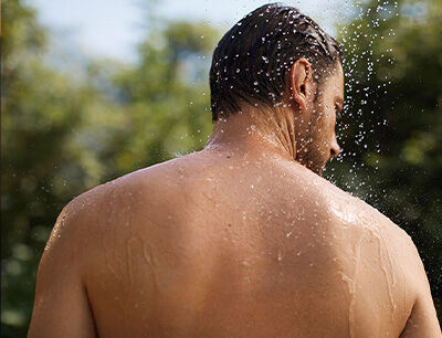 Ein Mann steht unter der Dusche.