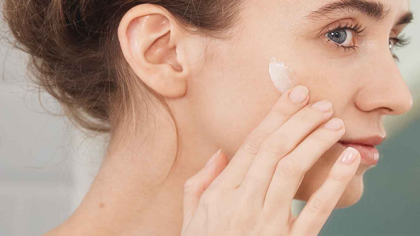 Frau mit Creme-Klecks im Gesicht. 