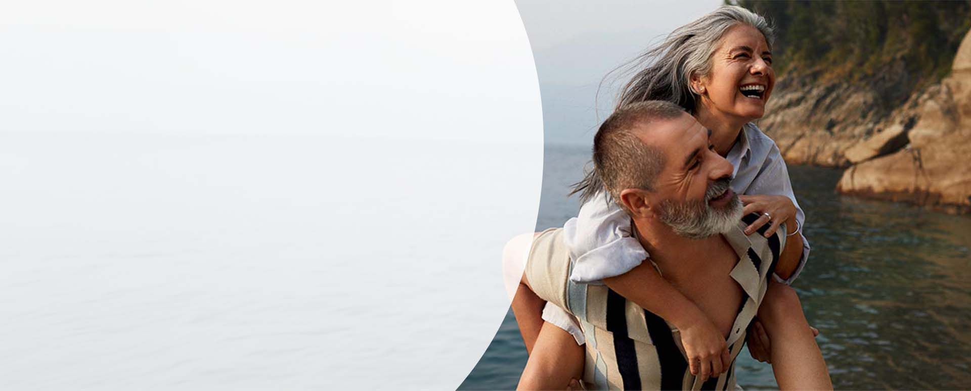 Mann tr&auml;gt Frau auf dem R&uuml;cken.