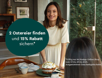 Frau steht am Tisch mit Kuchen und lacht.