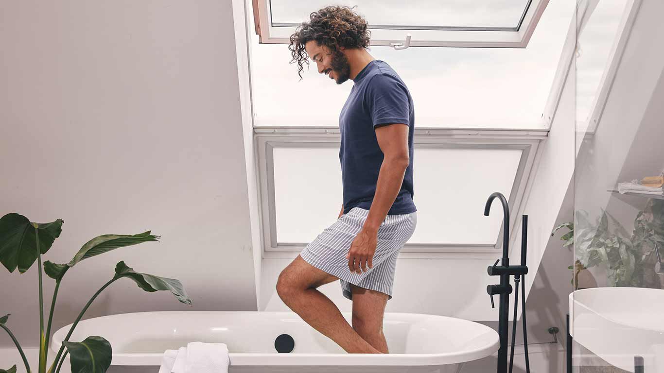 Mann praktiziert Wassertreten in der Badewanne zuhause.