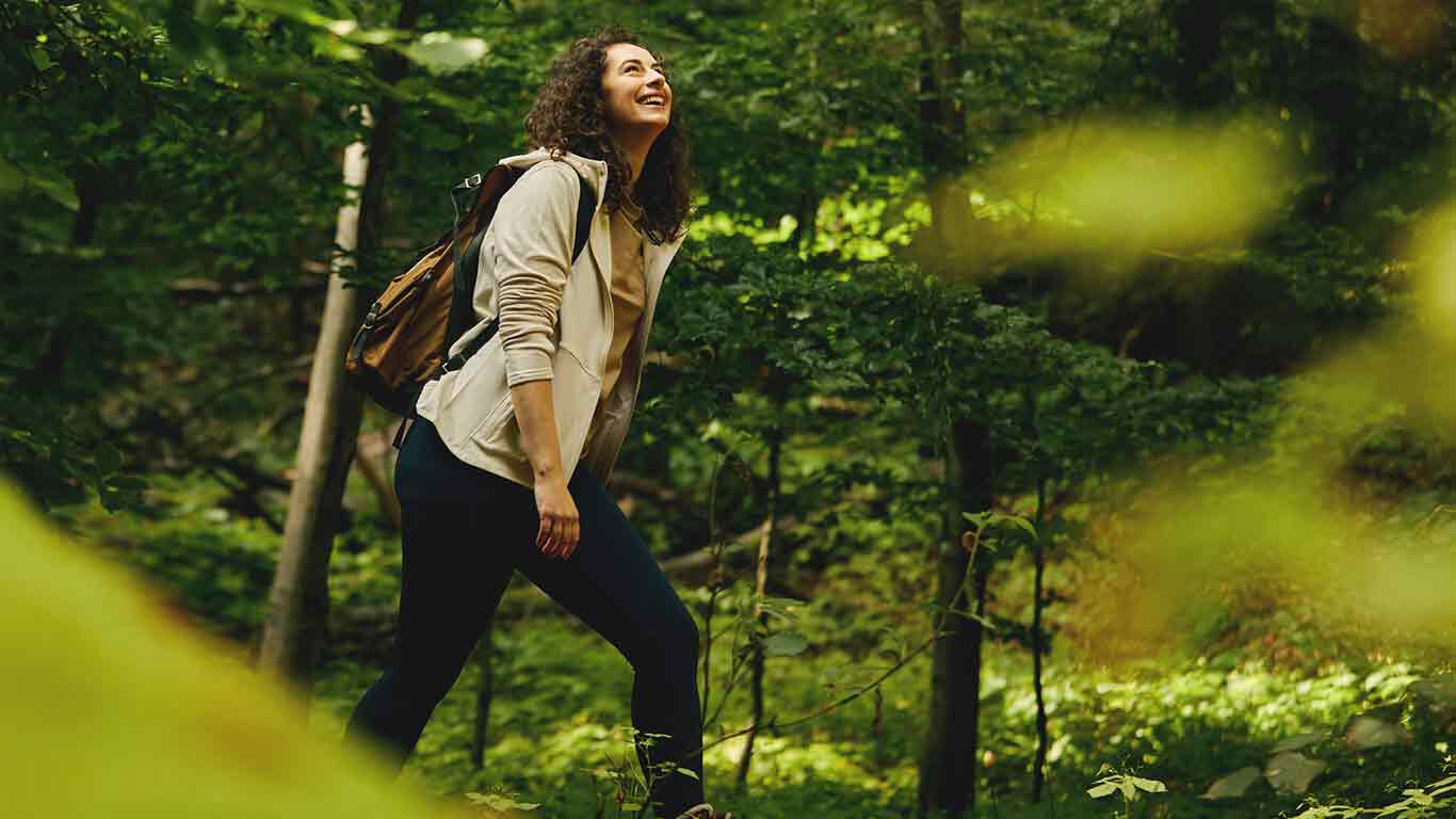 Frau spaziert im Wald.