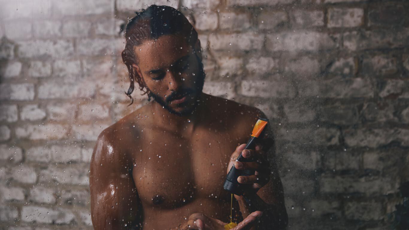 Ein Mann steht unter der Dusche nutzt die Kneipp 2-in-1 Dusche.