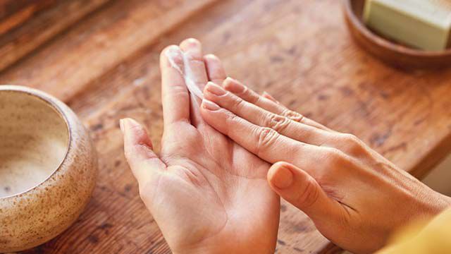 Nahaufnahme von Händen mit Handcreme. 