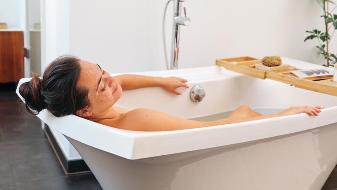 Nachhaltiges Badezimmer: Frau entspannt bei einem Dreiviertel-Bad nach Kneipp.