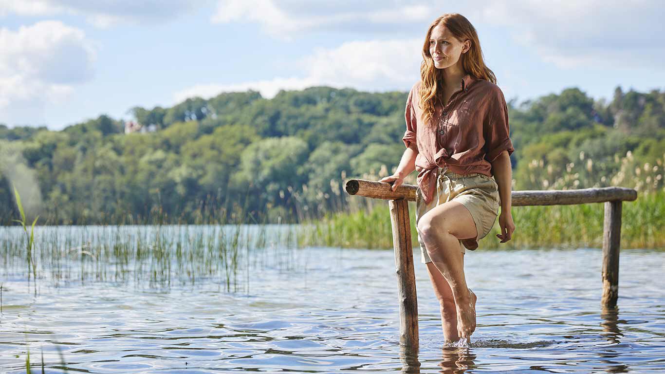 Frau beim Wassertreten in einem See. 