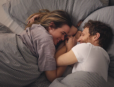 P&auml;rchen kuschelt im Bett.