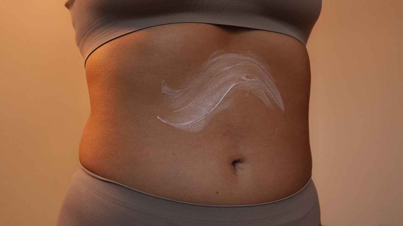 Creme auf Bauch verteilt. 