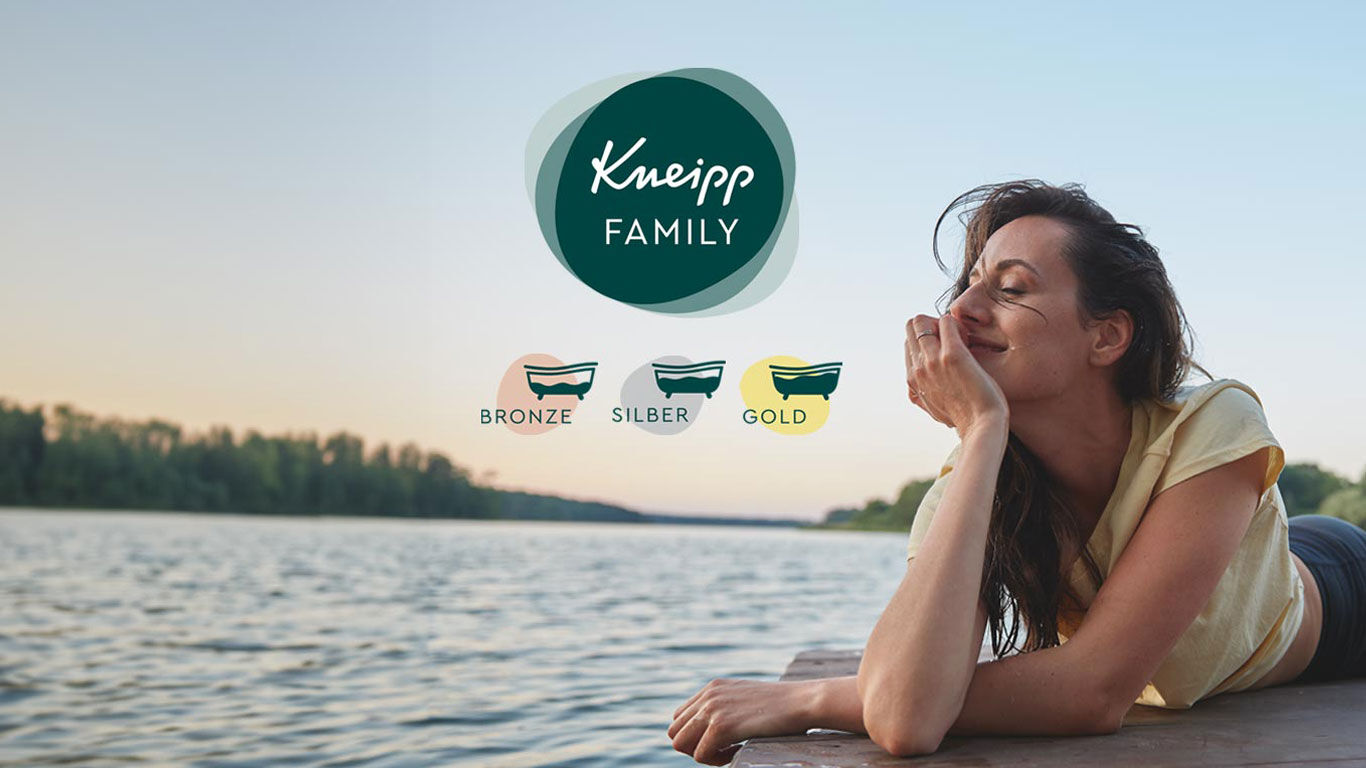 Frau liegt am Wasser und genießt die Abendsonne, Kneipp Family Logo und Status Icons Bronze, Silber, Gold