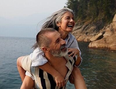 Mann tr&auml;gt Frau Huckepack.