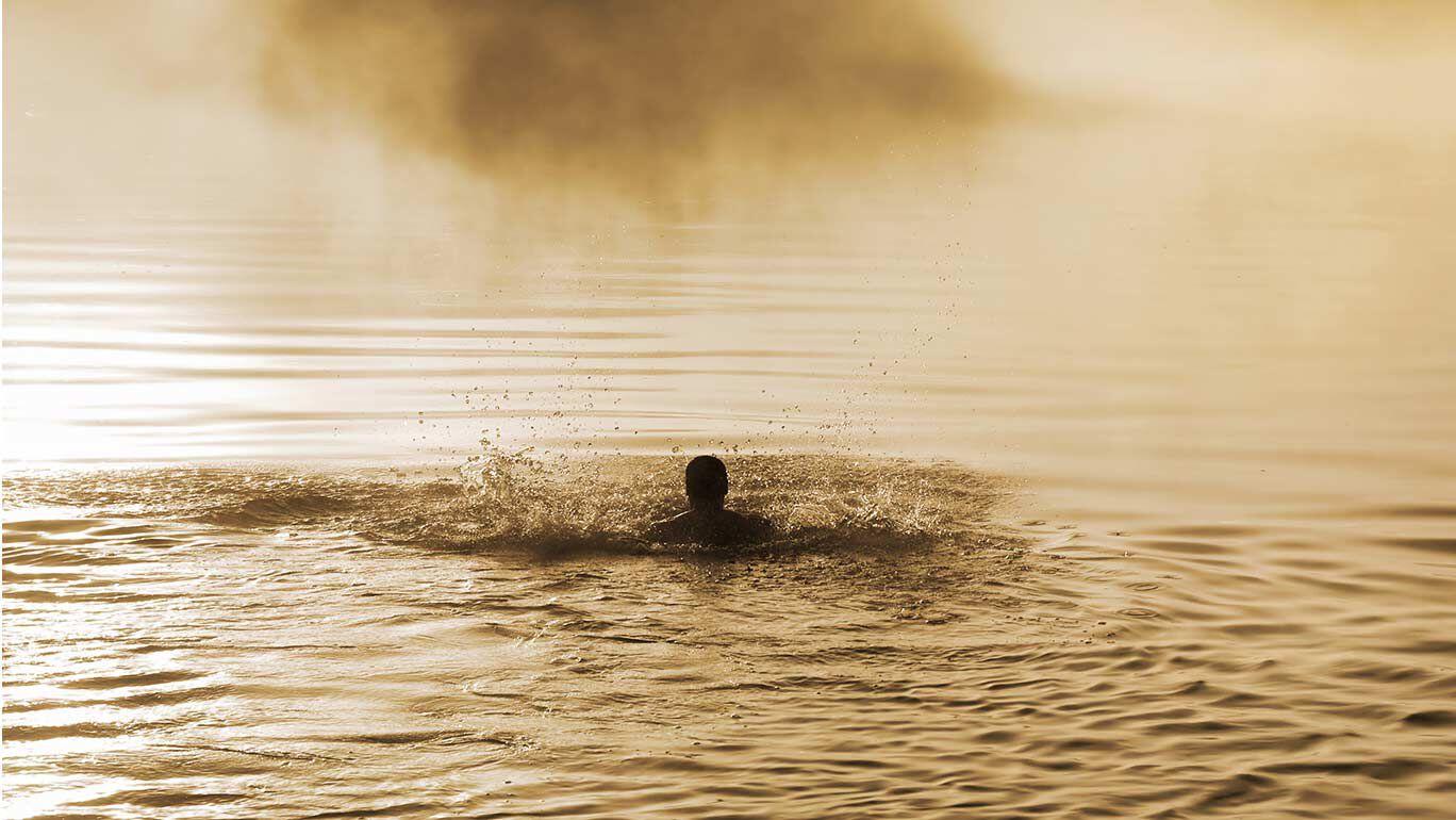 Mann schwimmt im Wasser. 