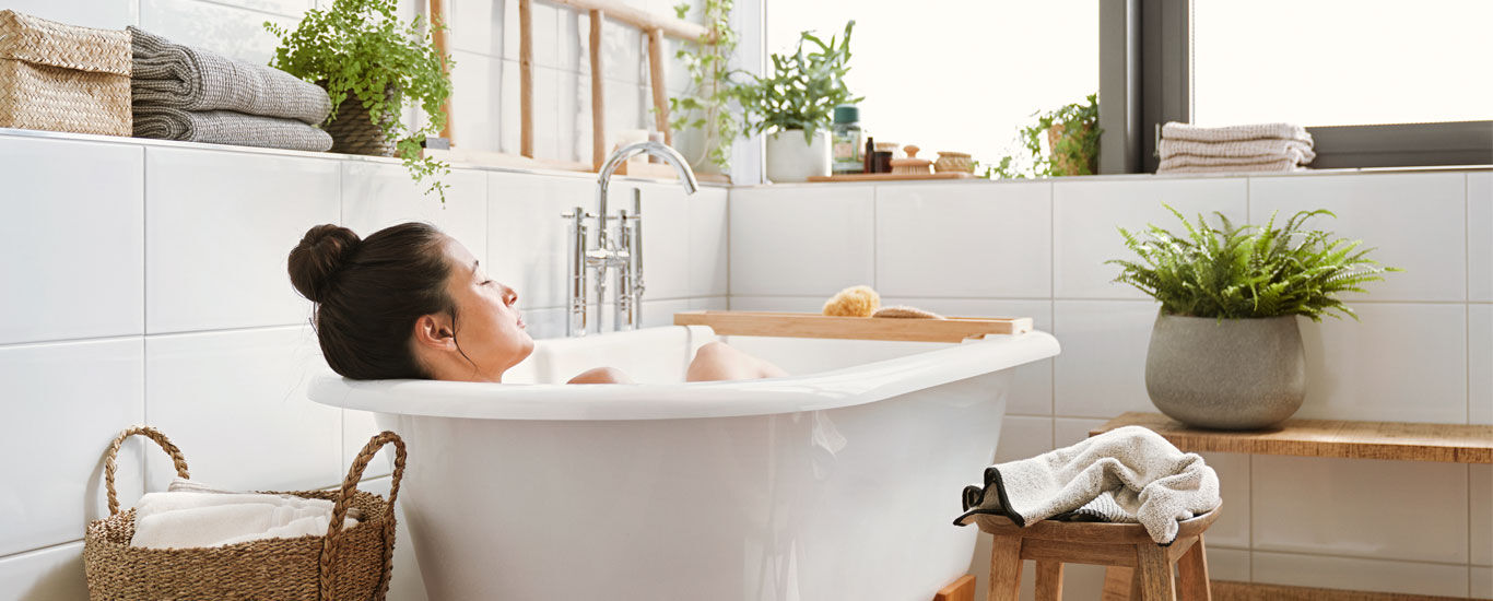 Frau liegt in der Badewanne und entspannt.