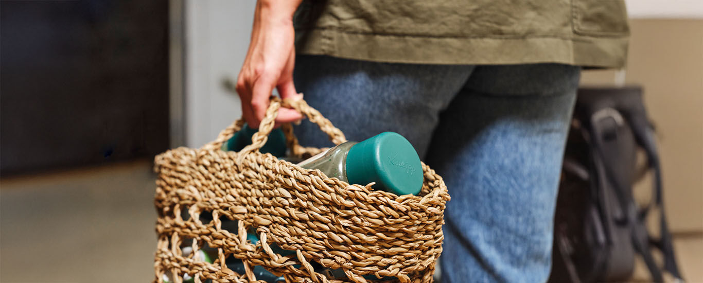 Frau hält in ihrer Hand einen Flechtkorb mit einer leeren Kneipp Badesalzdose 