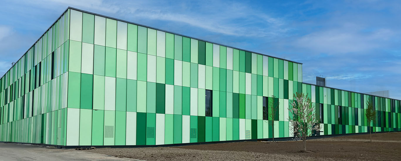 Au&szlig;enansicht der neuen Kneipp Produktionshalle. Moderner Bau mit Kacheln in unterschiedlichen Gr&uuml;nt&ouml;nen.