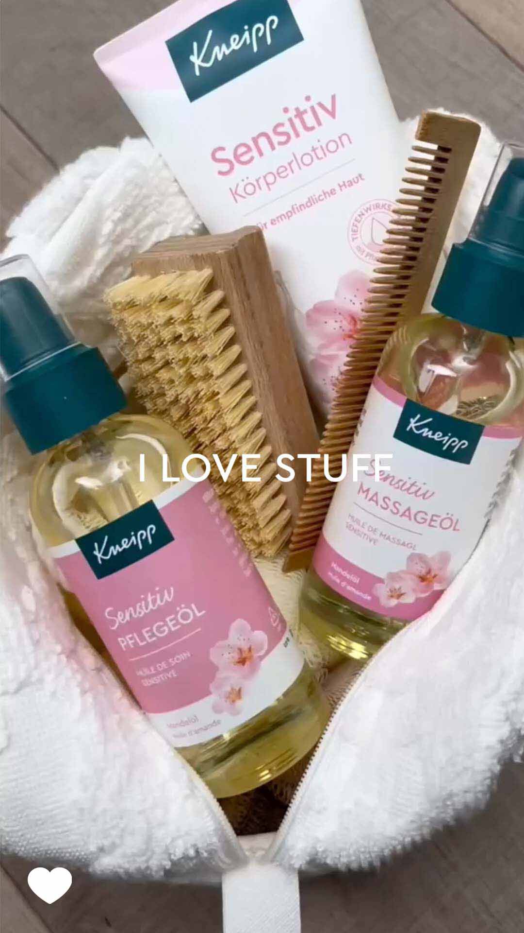 I Love Stuff Kneipp Sensitiv Pflegeprodukte im Wellness-Set: Körperlotion, Massageöl, Pflegeöl, Holzbürste und Kamm auf weißem Handtuch.