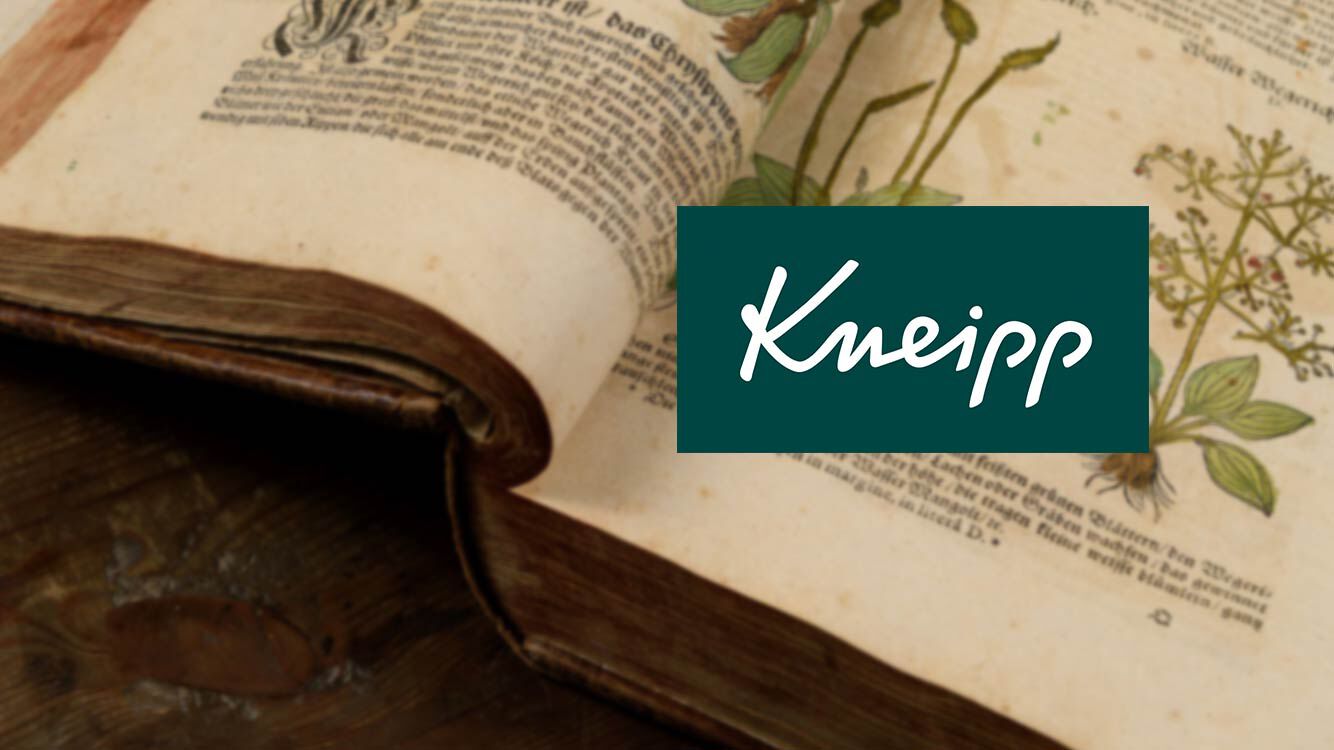 Aufgeschlagenes, historisches Buch, darauf Kneipp Logo. 