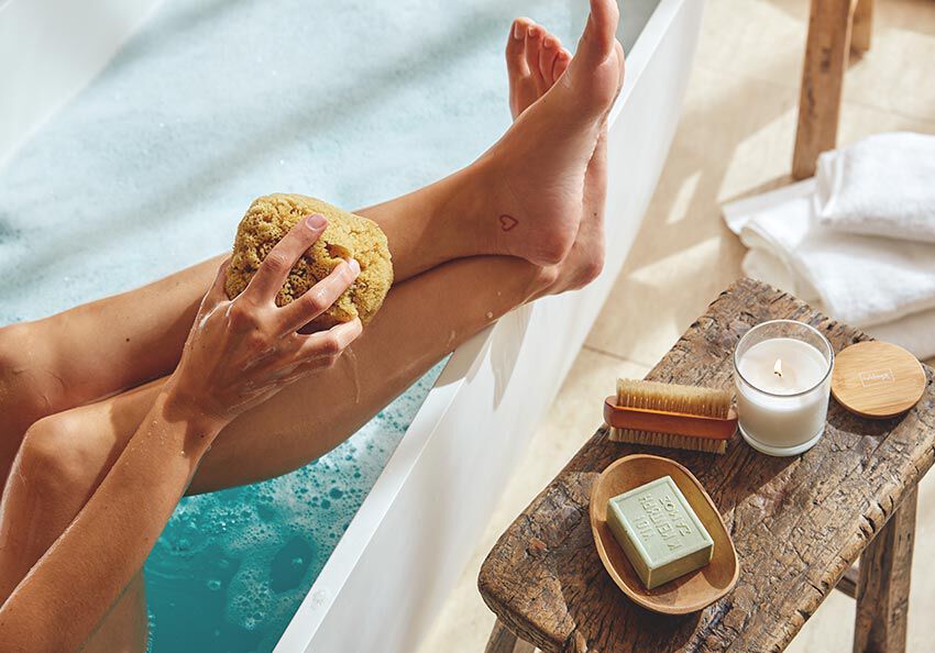 Beine h&auml;ngen aus der Badewanne. 