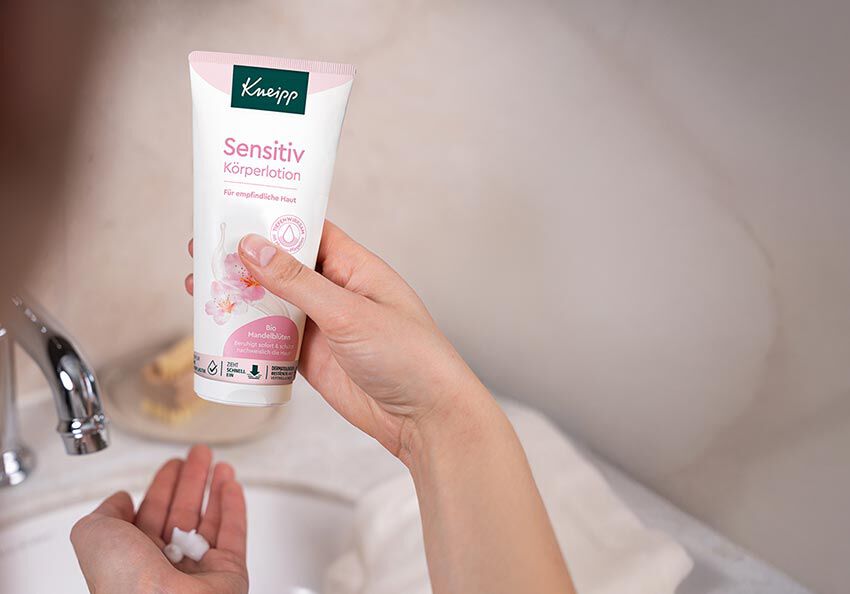 Kneipp Sensitiv Bodylotion wird über einem Wachbecken aus der Tube gedrückt.