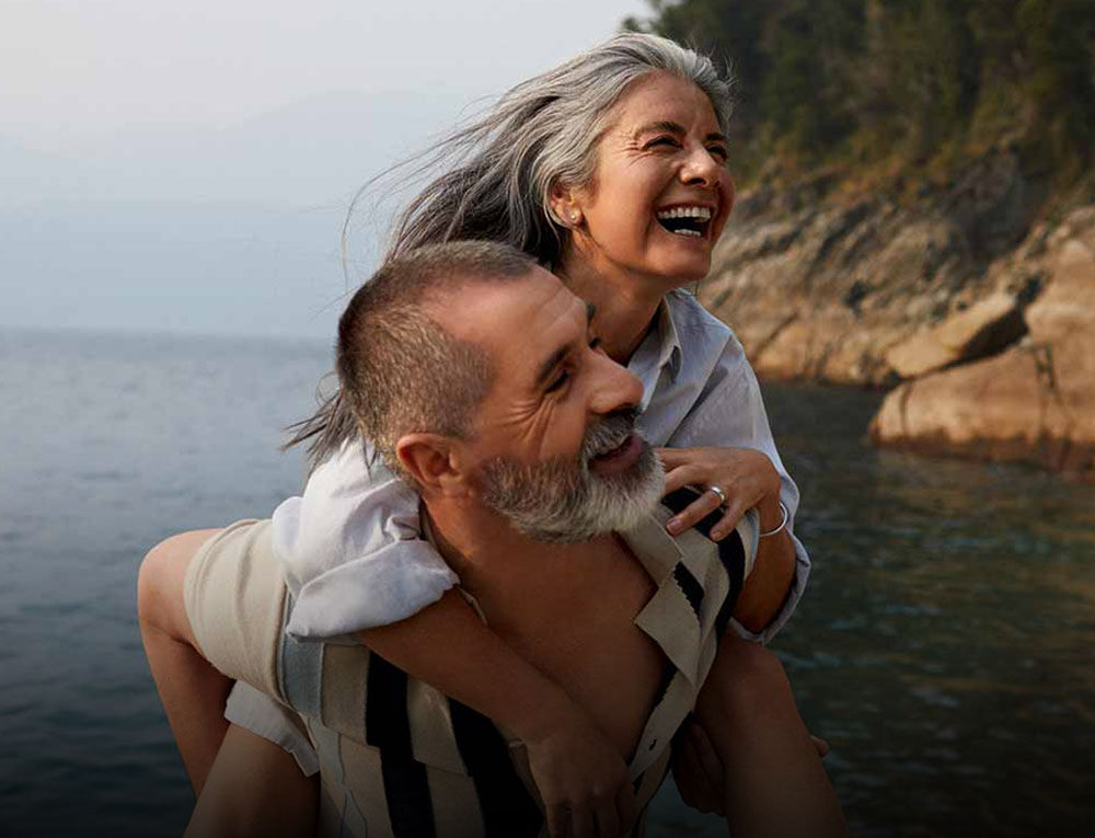 Mann tr&auml;gt Frau auf dem R&uuml;cken.