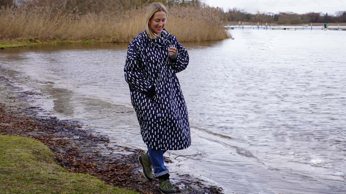 Alexa von Heyden telefoniert in ihrem Regenponcho bei einem Spaziergang. 