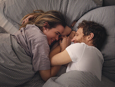 P&auml;rchen kuschelt im Bett.