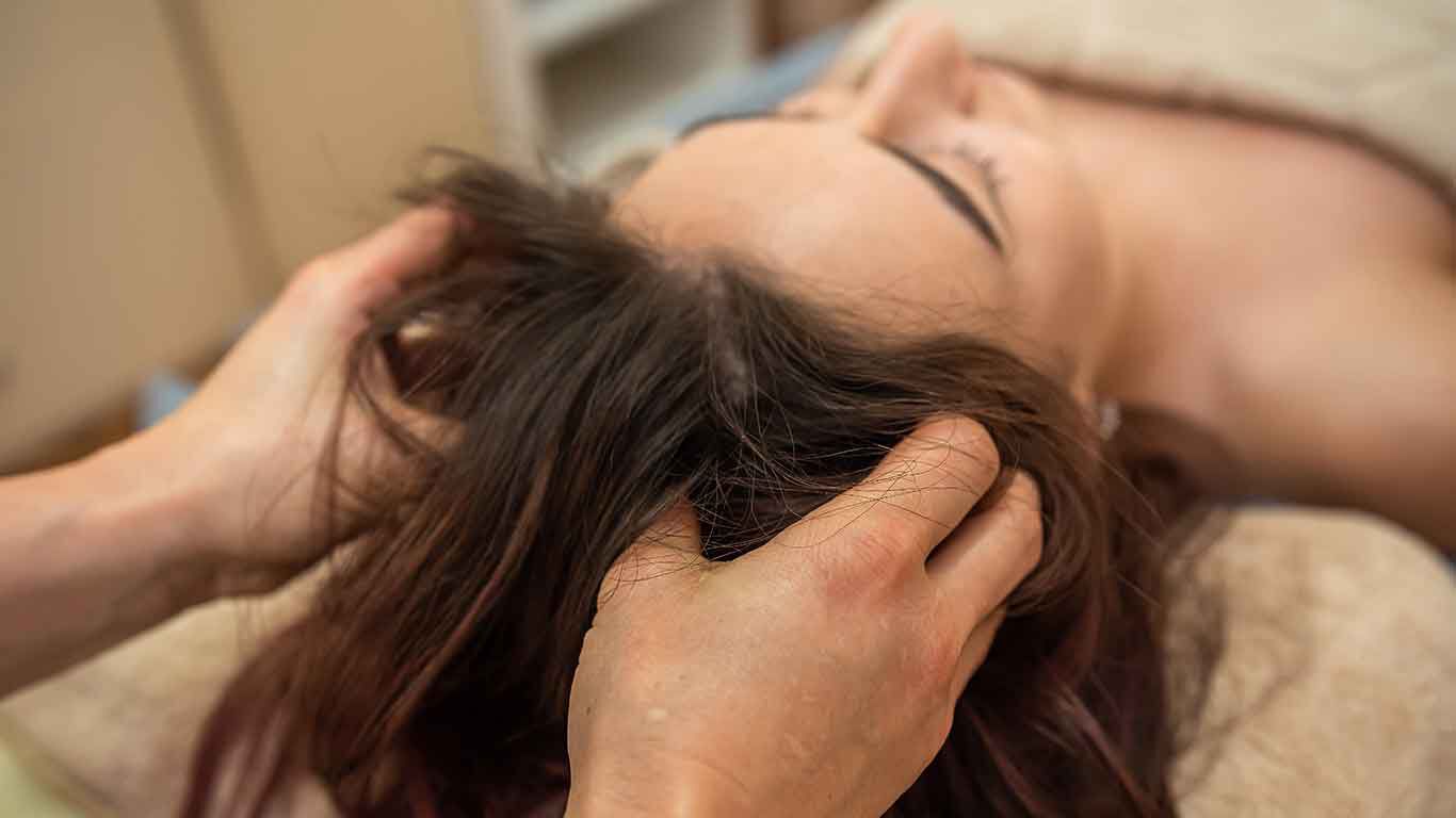 Frau während einer Kopfhautmassage. 