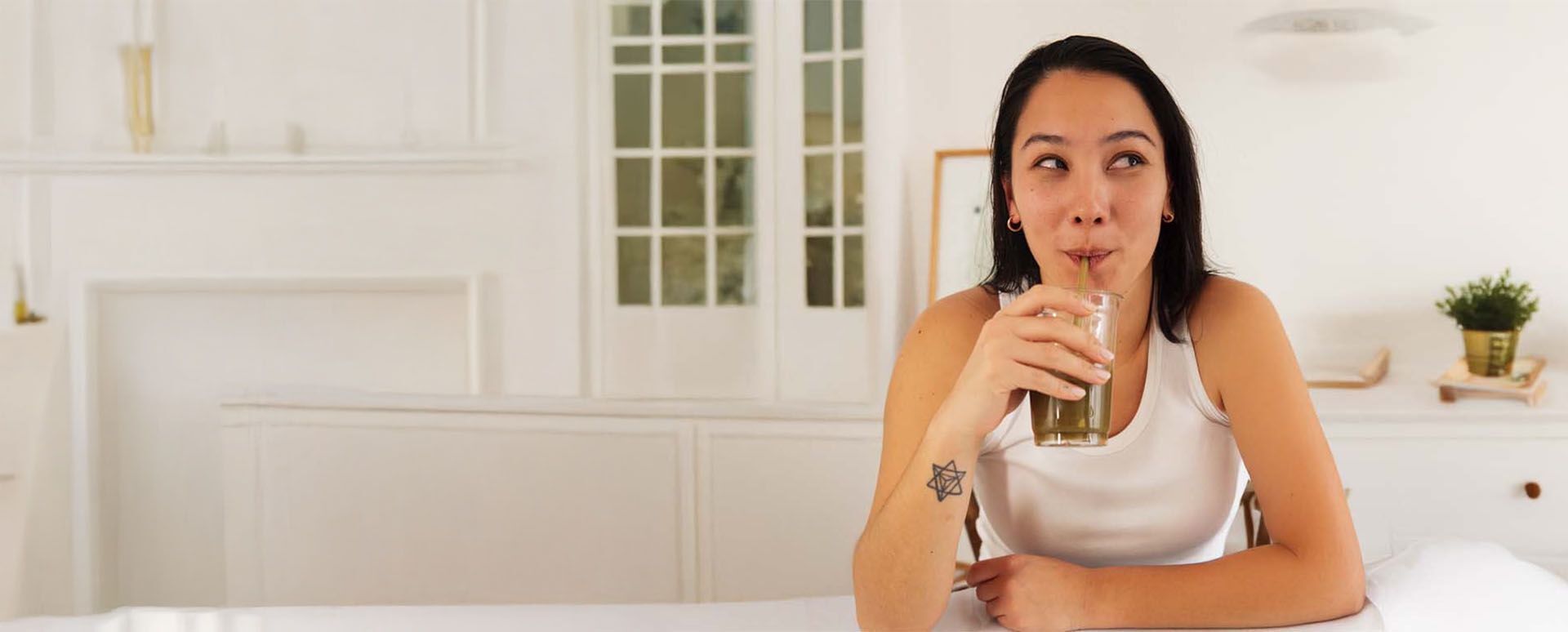 Frau trinkt aus einem Glas.