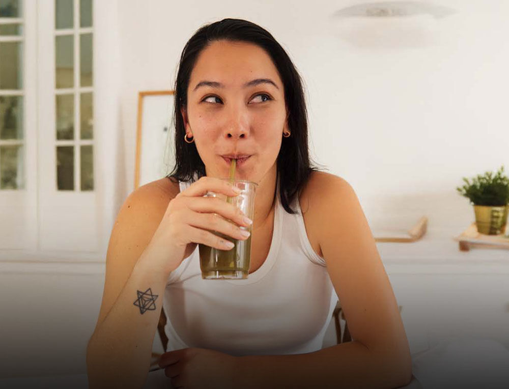 Frau trinkt aus einem Glas.